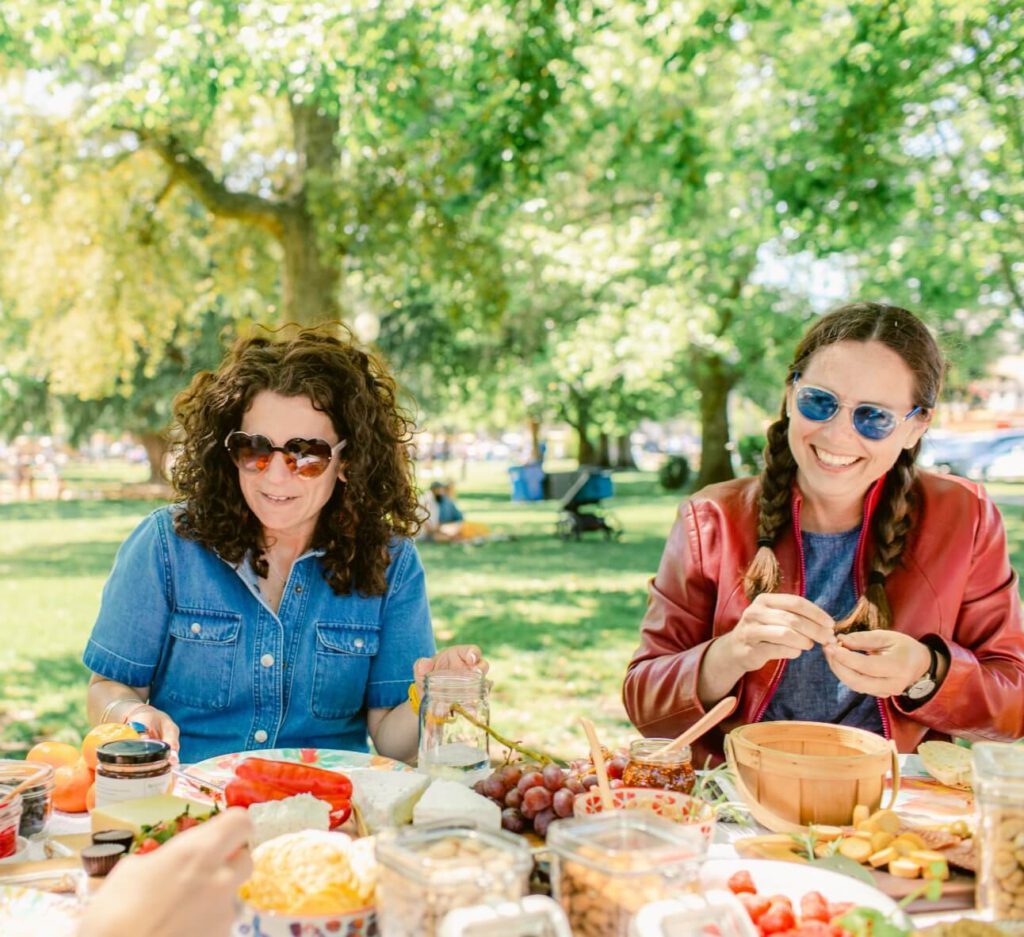 Two women eating a meal outdoors.